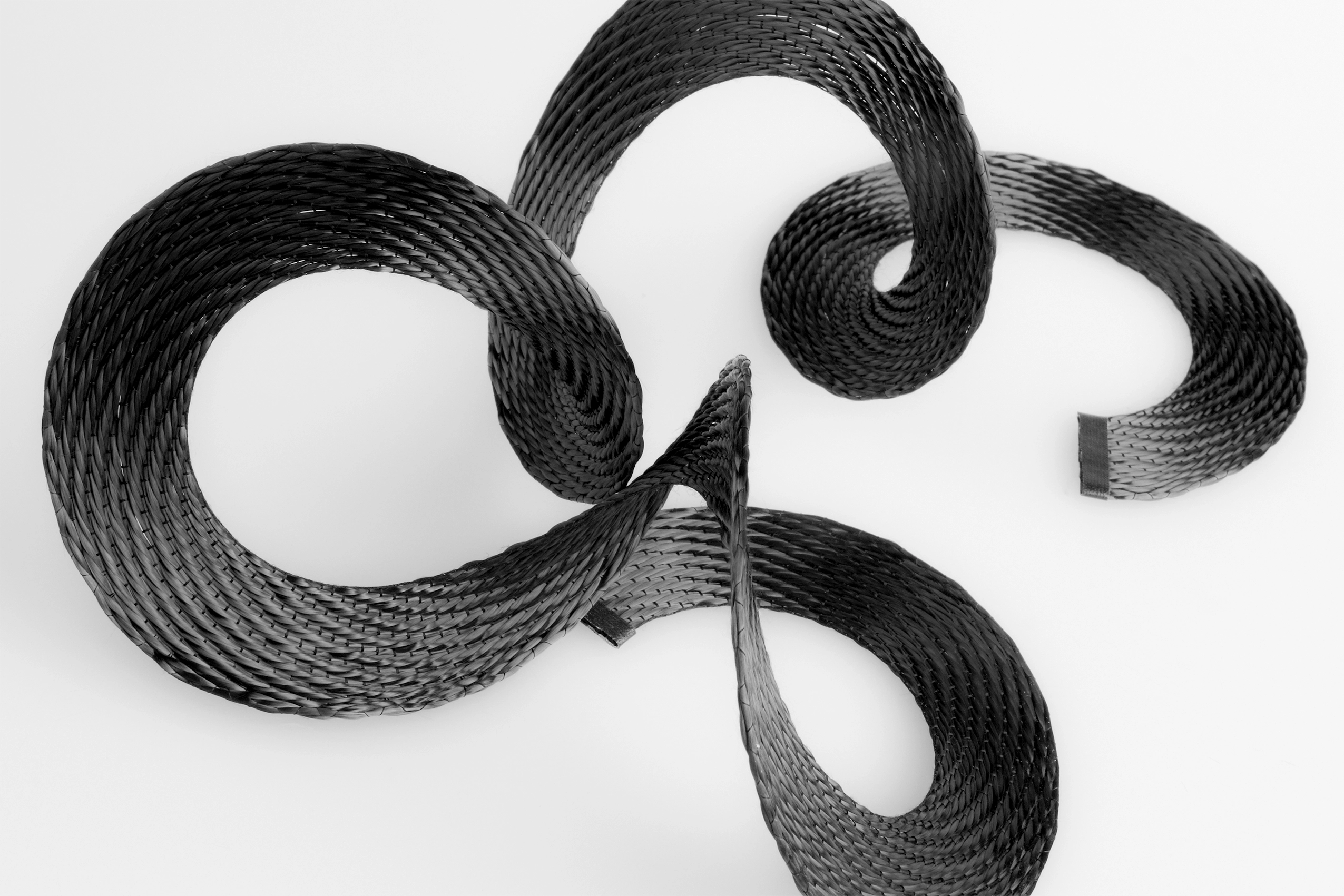 Top view of a black carbon spiral tape against a white background