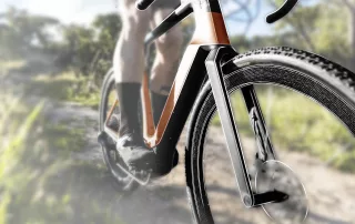 Close-up of a bicycle on a forest path with focus on the front wheel rim